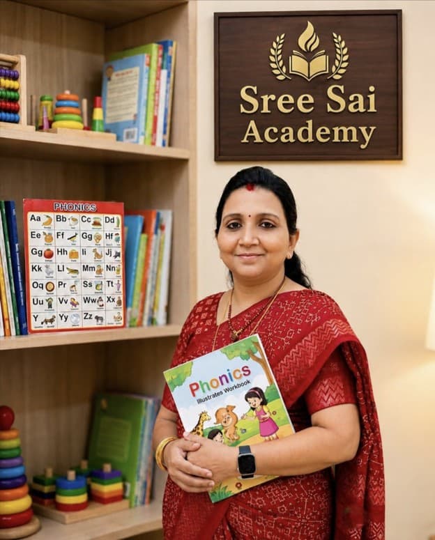 Mrs. Jayasreesudan, founder and mentor at Sree Sai Academy, holding a phonics workbook